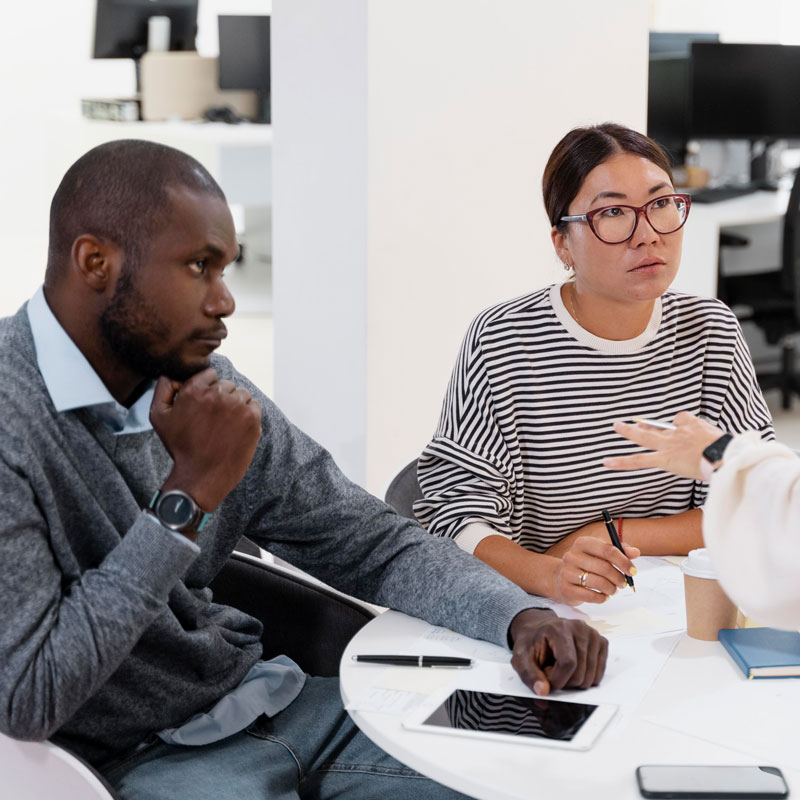two diverse young people sitting at a table with an attorney representing divorce mediation