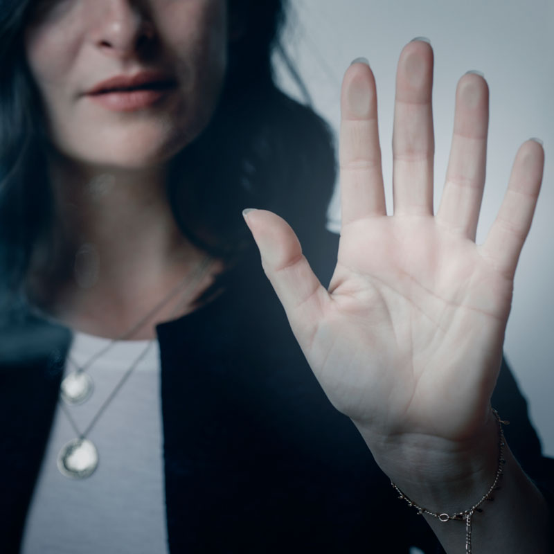a woman pressing her hand against a window representing orders of protection
